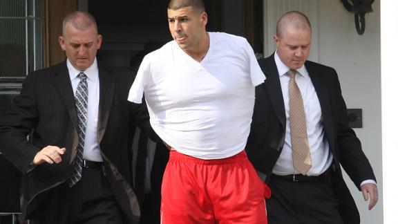 Aaron Hernandez is led away from his home in handcuffs.