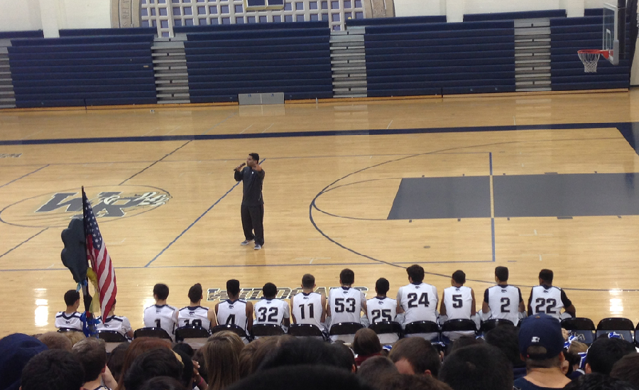 Coach Shant Bicacki addresses the home crowd with the 2013-2014 varsity squad looking on.
