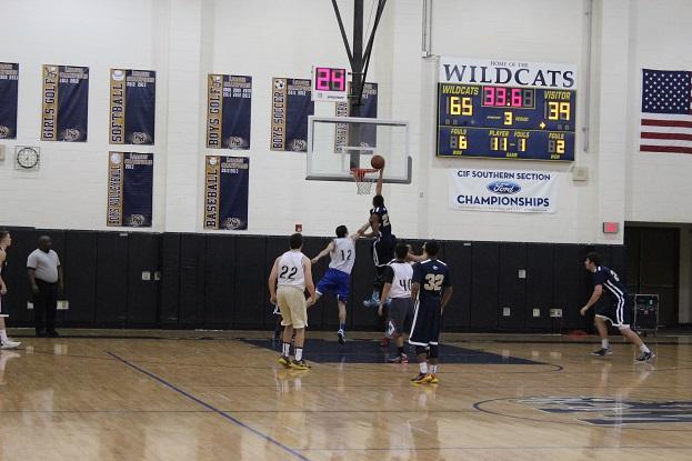 Milan Taylor (22) dunks on alumni Chuck Silver (12).