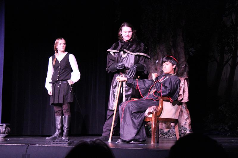 (From left-right) Hilton (Caitlin Ure) attends to the Sheriff of Notthinghamshire (Eddie Michels) as he talks to the Bishop (Nicholas Aguilar)