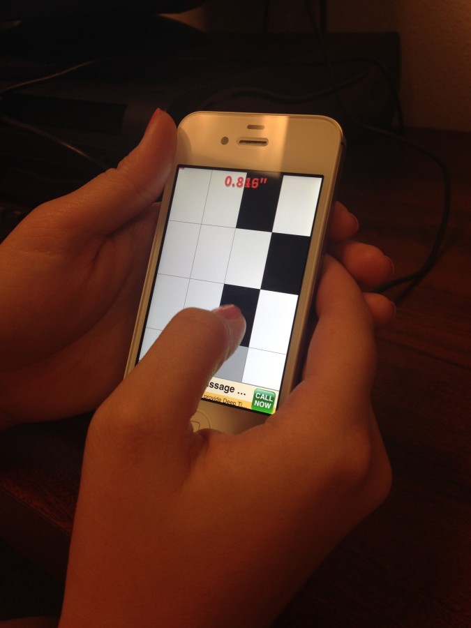 Student playing Piano Tiles. 