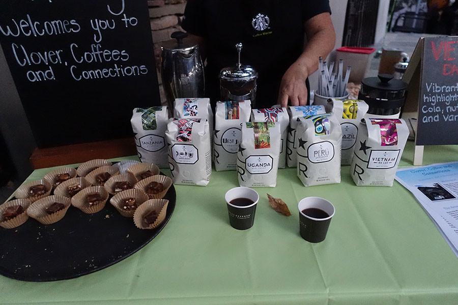 Employees set up a display of Starbucks reserve coffees and salted caramel squares.