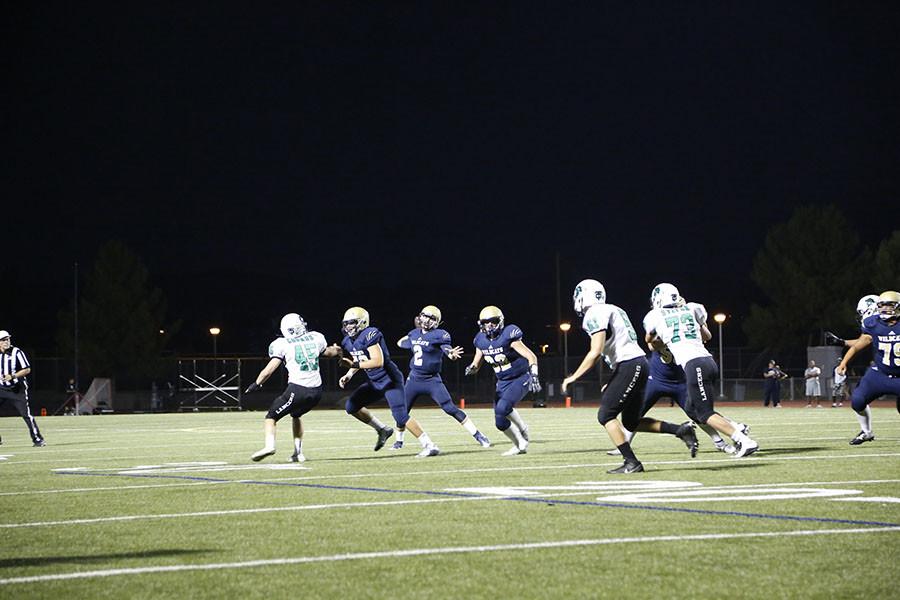 West Ranch quarterback Jackson Clark looks downfield to pass the ball off to one of his receivers.