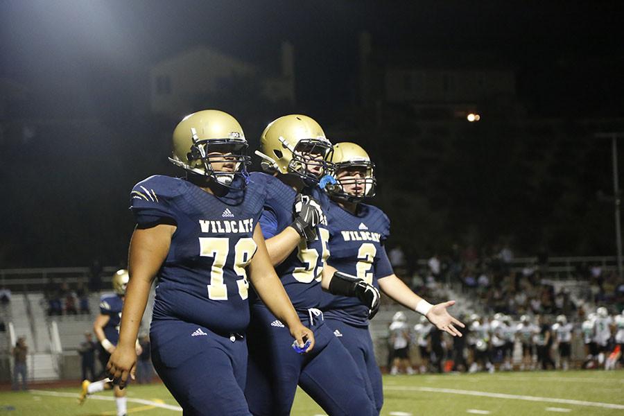 West Ranch's Ian Sibil, Matthew Padilla, and Jackson Clark discuss a running play.