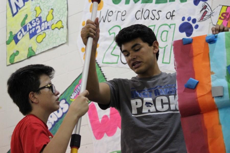 Teamwork is key in rally set-ups. Freshman Carter Williams lends a helping hand to junior Jesse Garcia.