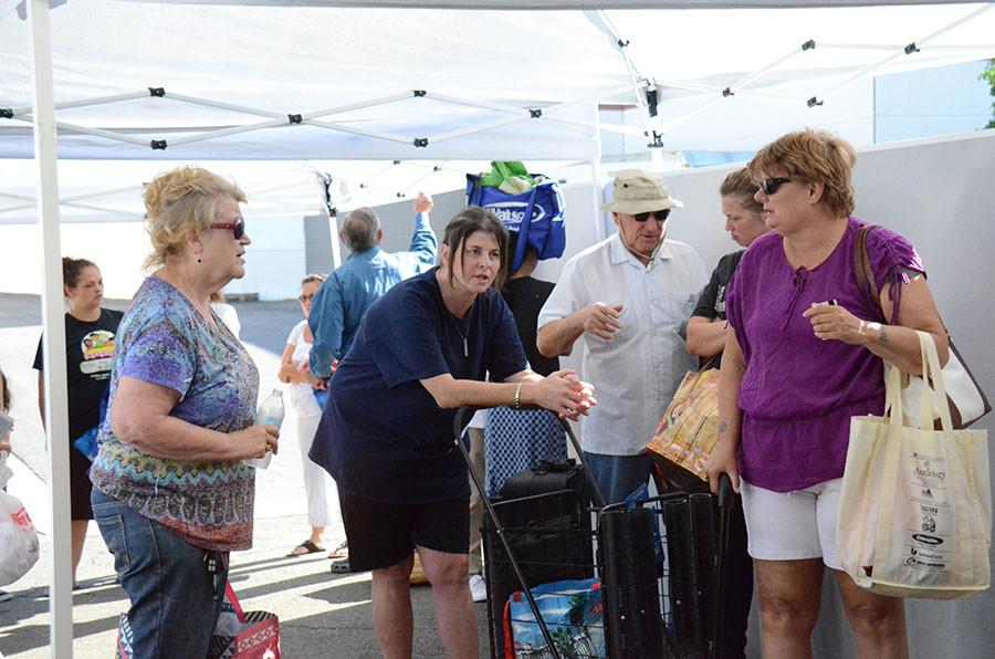 Clients line up with their market bags, waiting to be checked in.