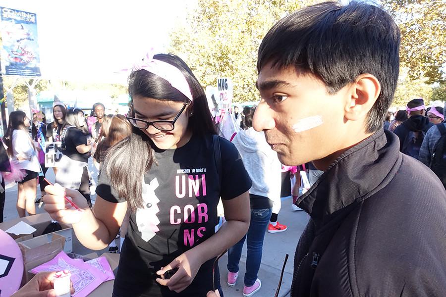 West Ranch senior Shazreh Hassan paints West Ranch junior Mir Zaman's face, preparing for the long day.