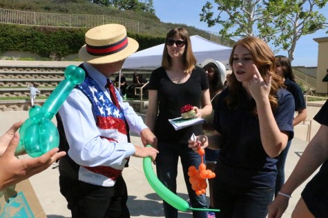 Sophomore Chloe Koons watches her balloon animal get made after the performance.