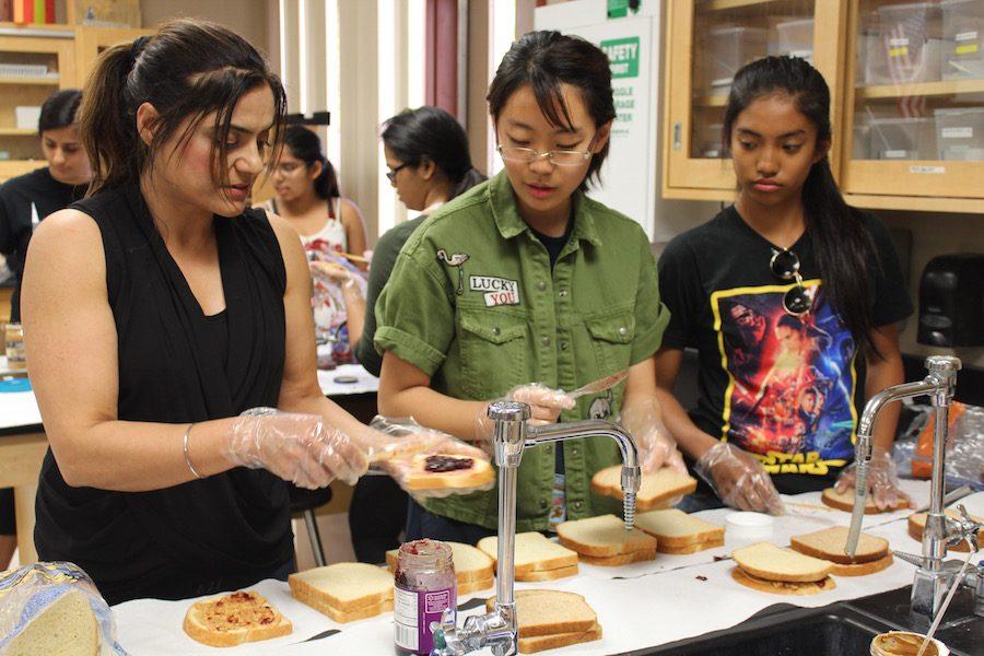Mayan (left) gives a hand, helping Lauren Lee (middle) and Raylene Factora (right) make sandwiches.