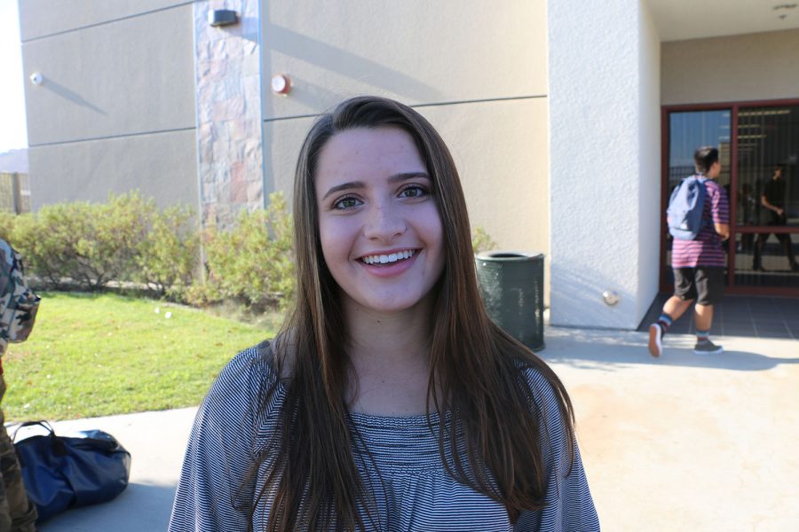 Hannah Landon smiles with a flushed and embarrassed face after walking down the red carpet.