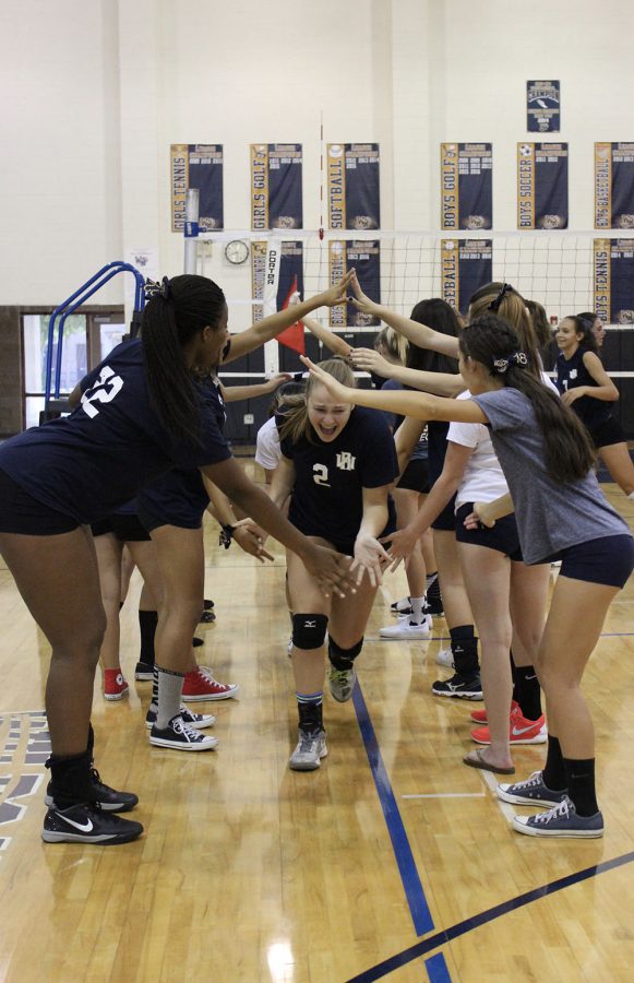 Varsity runs through a tunnel of their supporting teammates before their match.