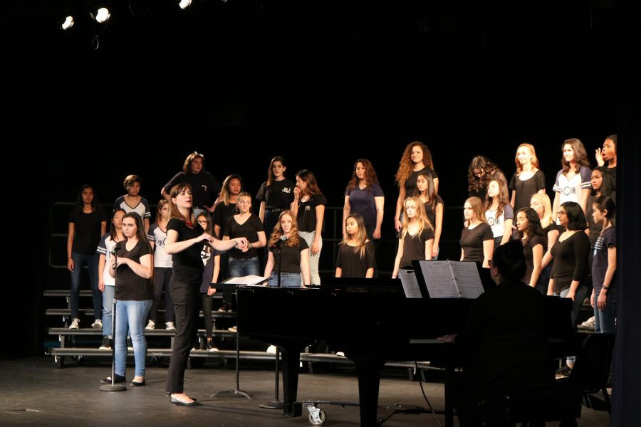 Molly Peters, choir director, leads the women's choir in a song