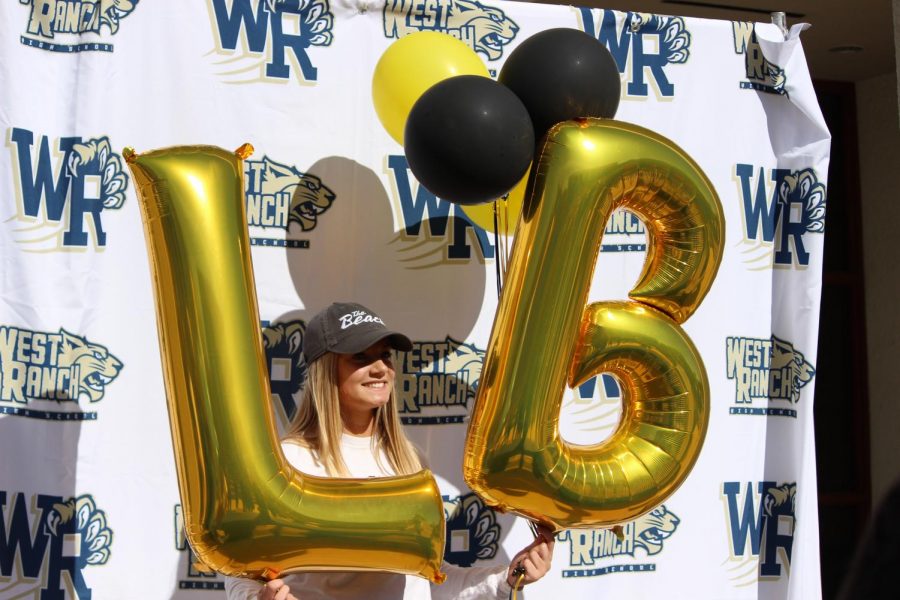 Sarah Olsen stands with balloons after signing her letter of intent. 